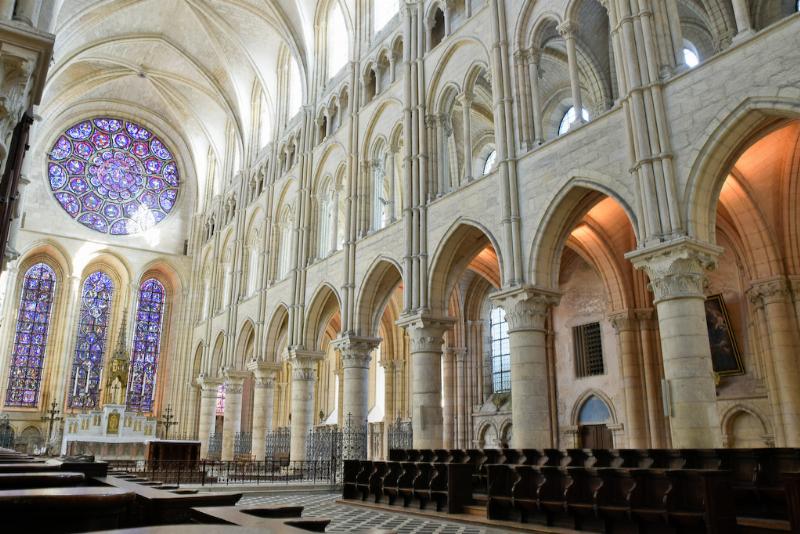 L'intérieur majestueux de l'église Notre-Dame-des-Champs à Paris, avec sa nef spacieuse et son autel principal éclairé.